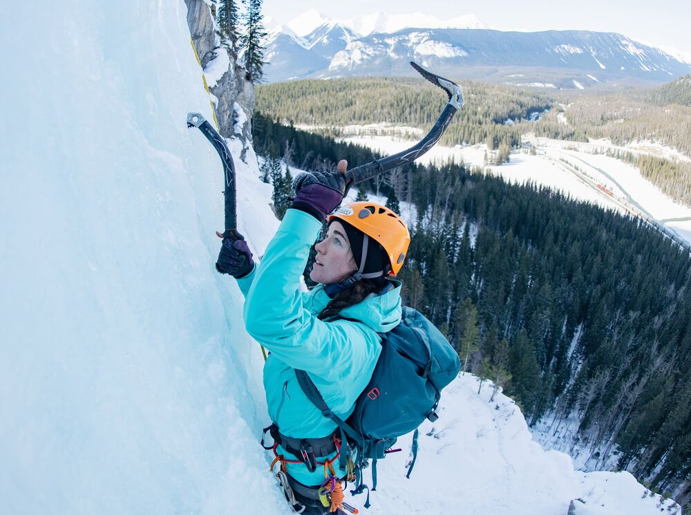 A person ice climbing on a frozen waterfall in Banff National Park