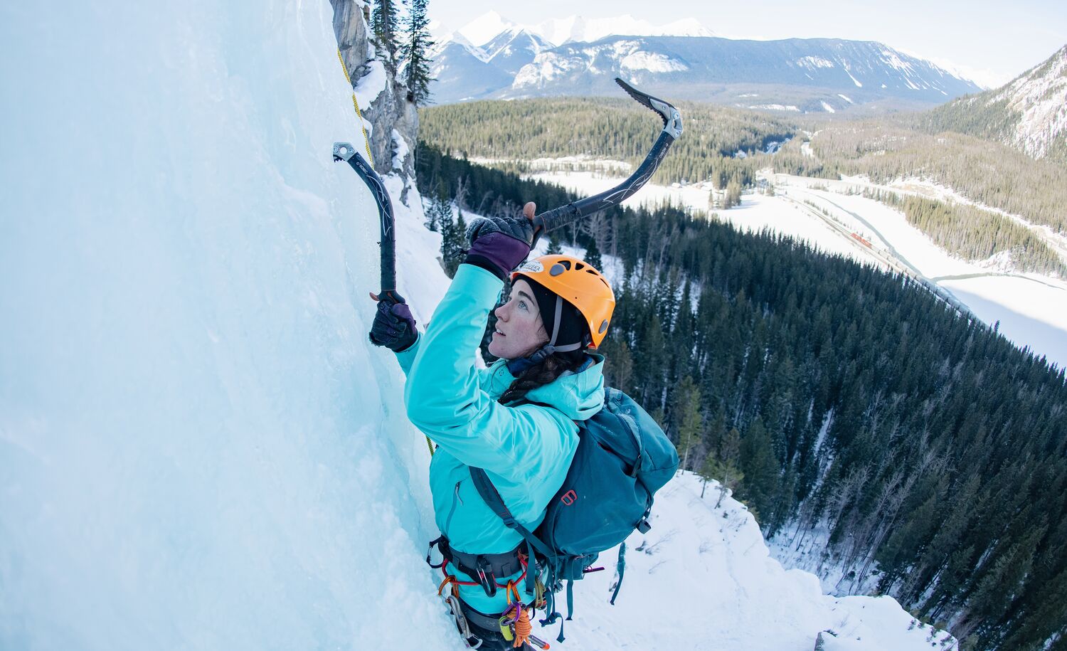 A person ice climbing on a frozen waterfall in Banff National Park
