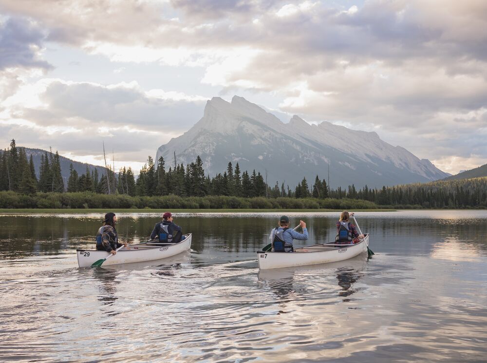 Four people in two canoes on Vermillion Lakes in Banff National Park