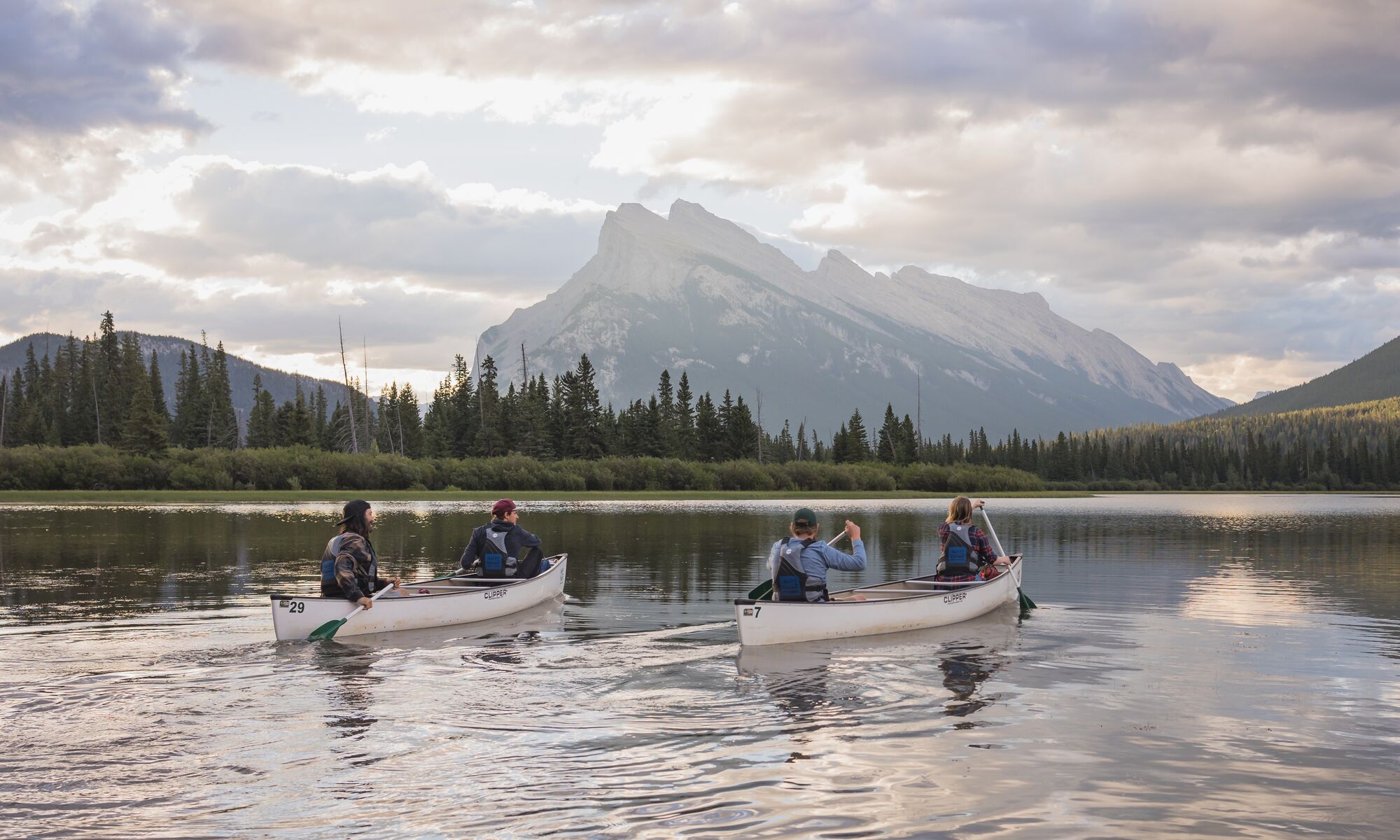 Four people in two canoes on Vermillion Lakes in Banff National Park