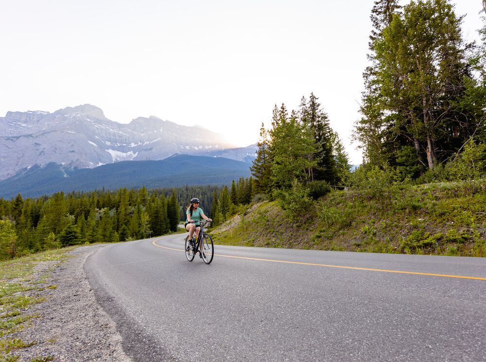 A person bikes on the Minnewanka Loop in Banff National Park.