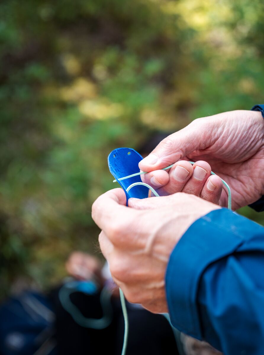 Hands tie a medicine bag as part of a bike tour in Banff National Park focused on the area's indigenous history.