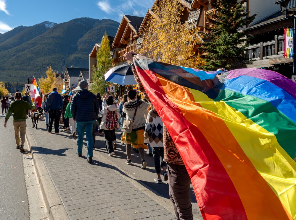 People in the pride parade walking down Banff Avenue in Banff National Park