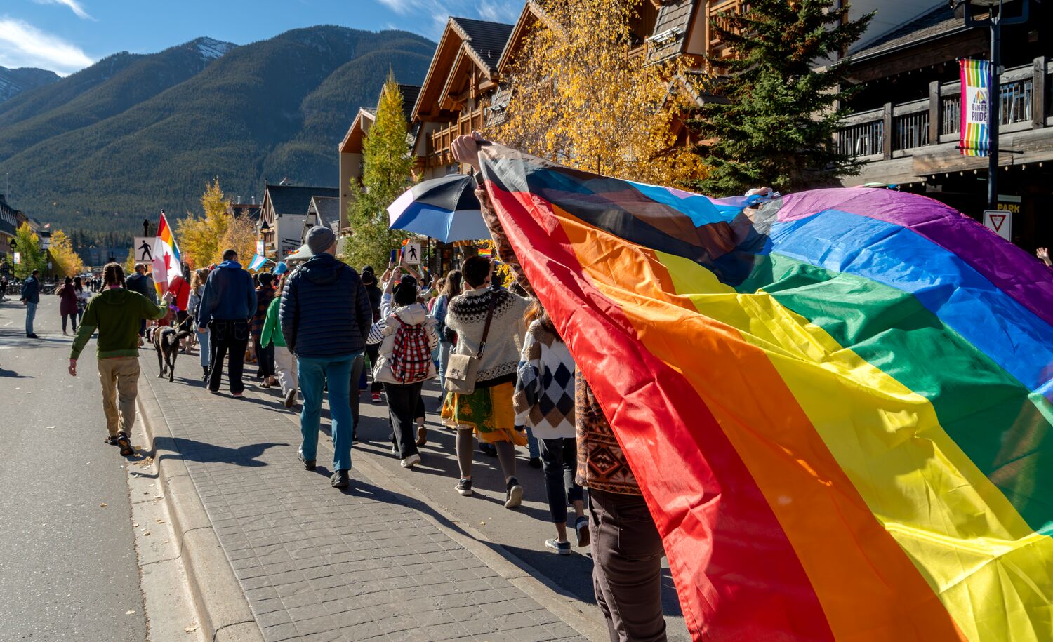 People in the pride parade walking down Banff Avenue in Banff National Park