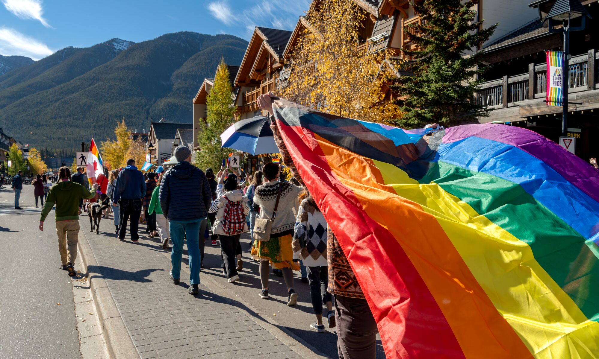 People in the pride parade walking down Banff Avenue in Banff National Park