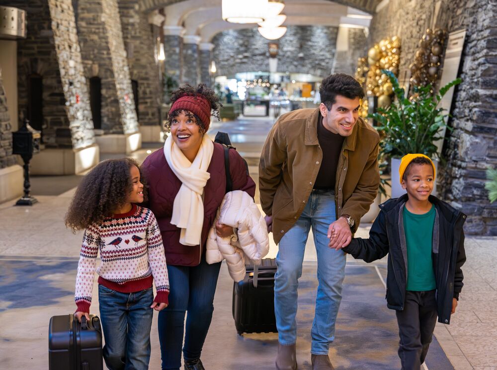 A family of four checking into the Fairmont Banff Springs at Christmas in Banff National Park
