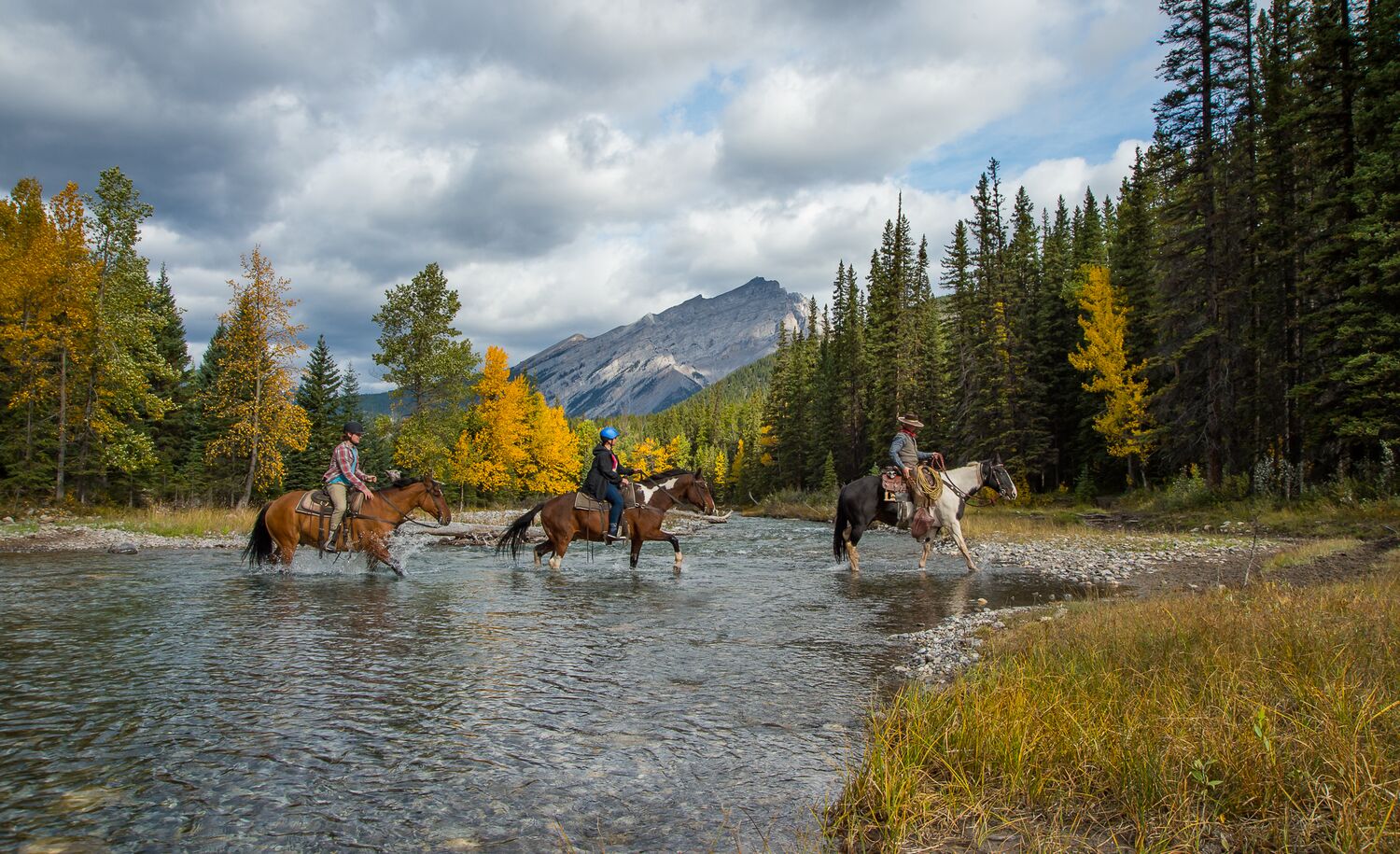 Three people on a guided horseback tour in Banff National Park