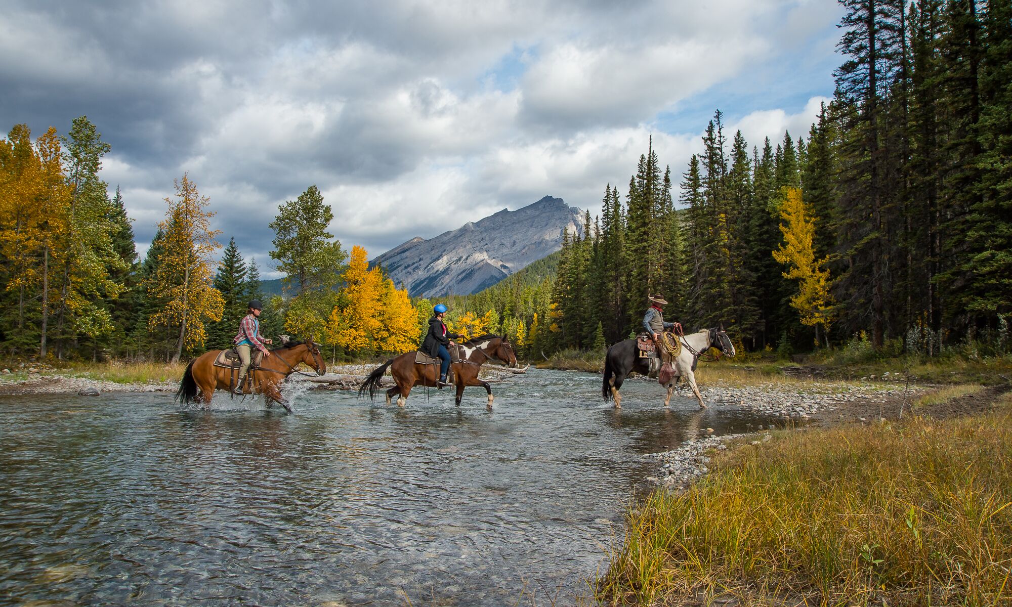 Three people on a guided horseback tour in Banff National Park
