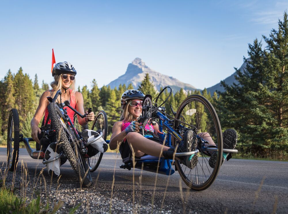 Two hand-bike riders on a bike ride on the Bow Valley Parkway in Banff National Park.