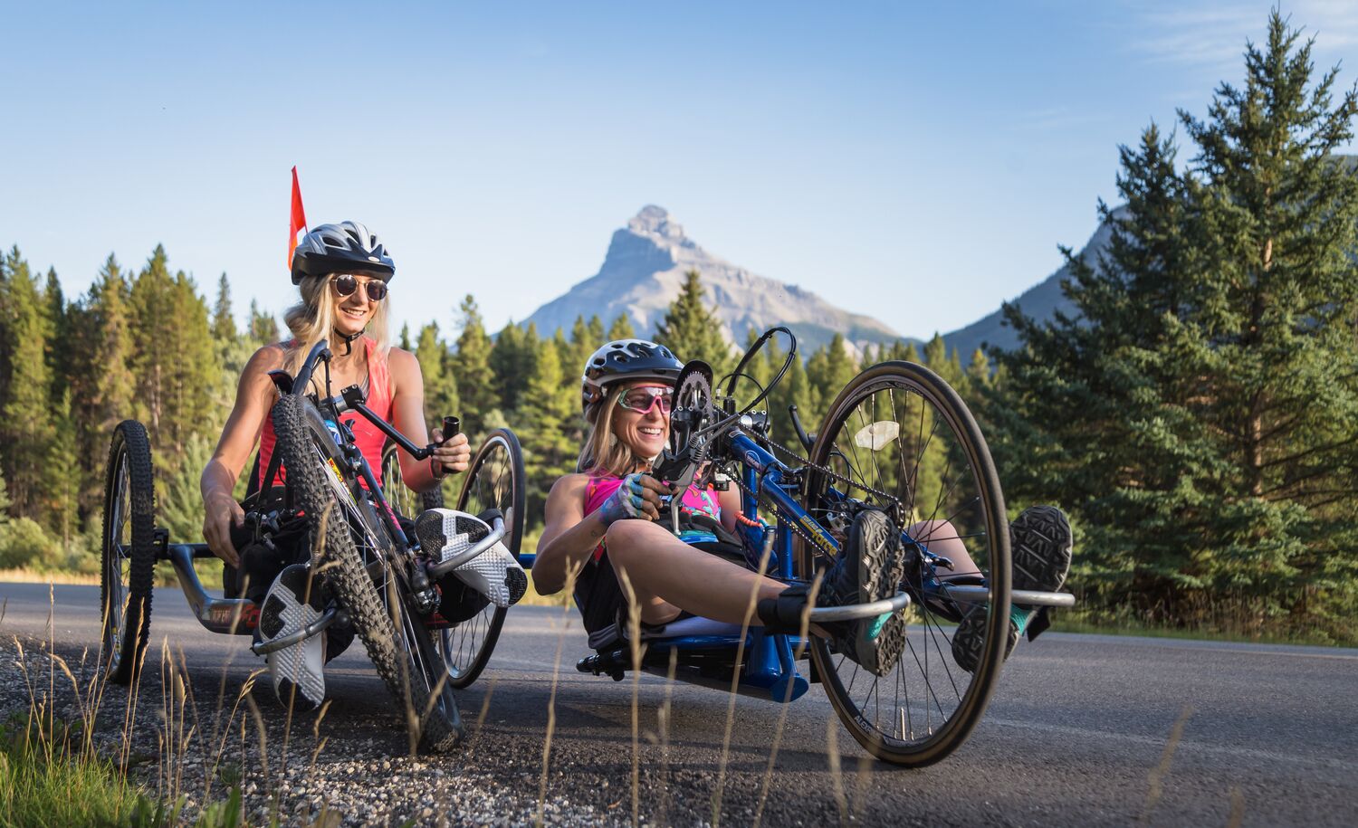 Two hand-bike riders on a bike ride on the Bow Valley Parkway in Banff National Park.