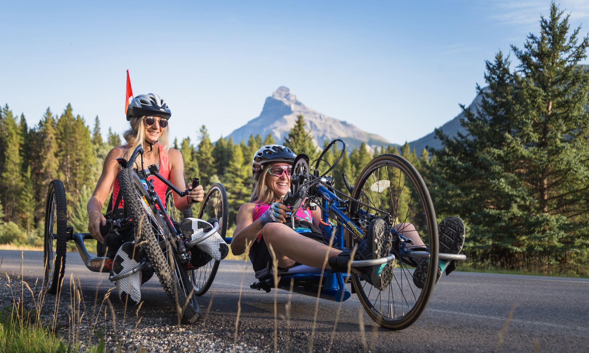 Two hand-bike riders on a bike ride on the Bow Valley Parkway in Banff National Park.