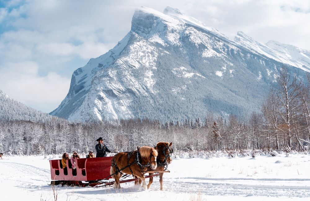 Three people on a sleigh ride in Banff National Park