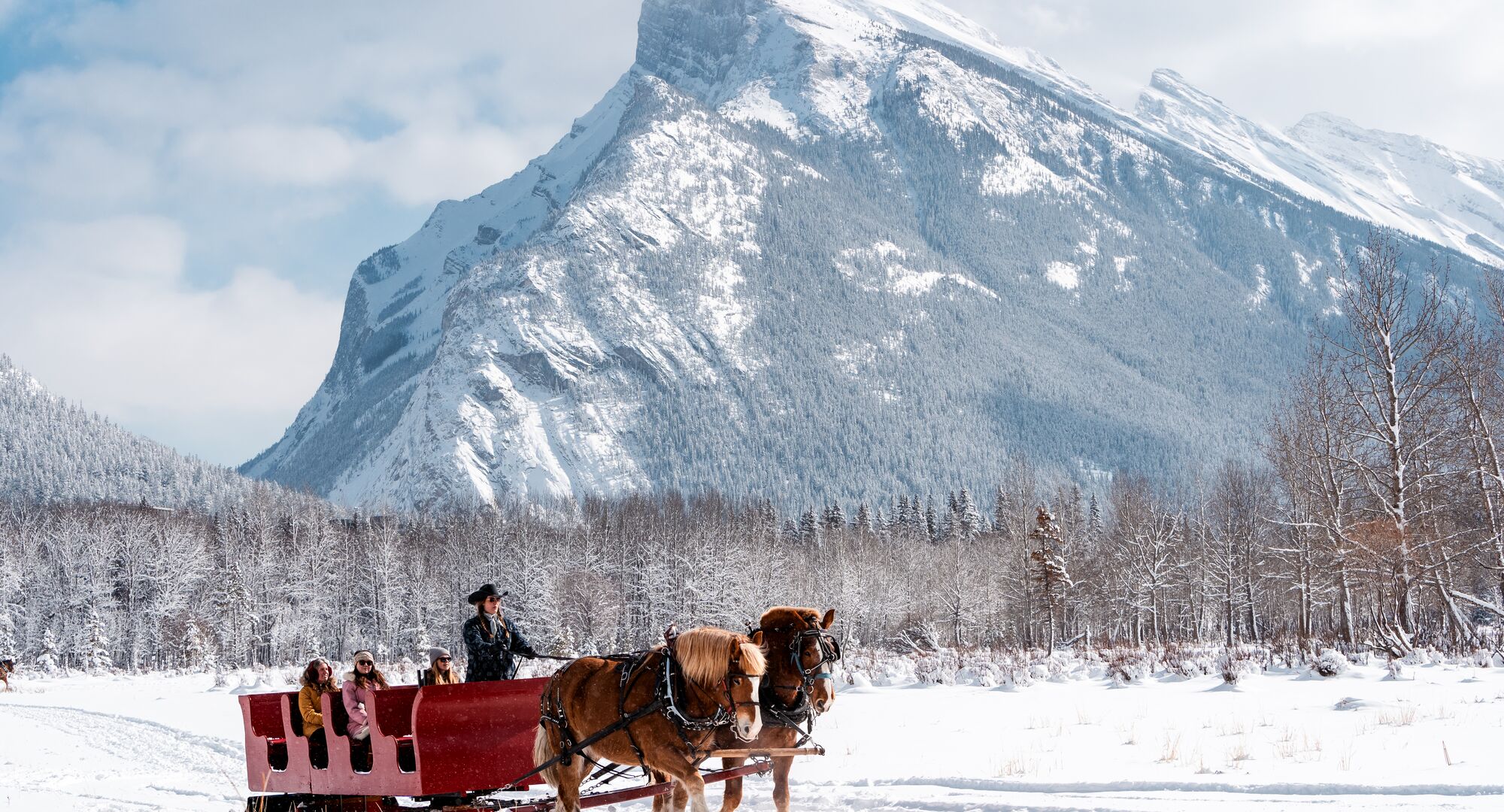 Three people on a sleigh ride in Banff National Park