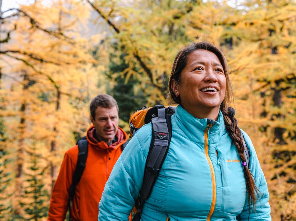 Two people hiking through larch trees in Banff National Park