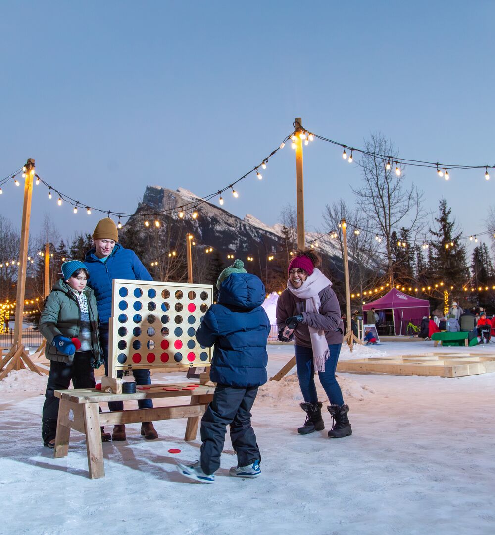 A family of four playing at the play zone during the SnowDays Festival in Banff National Park