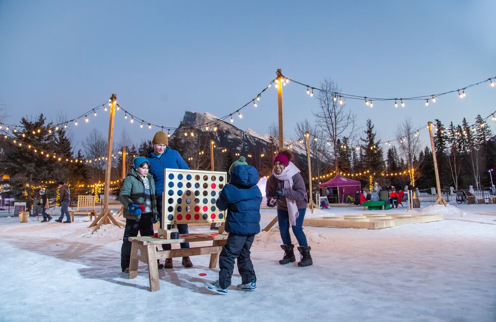 A family of four playing at the play zone during the SnowDays Festival in Banff National Park