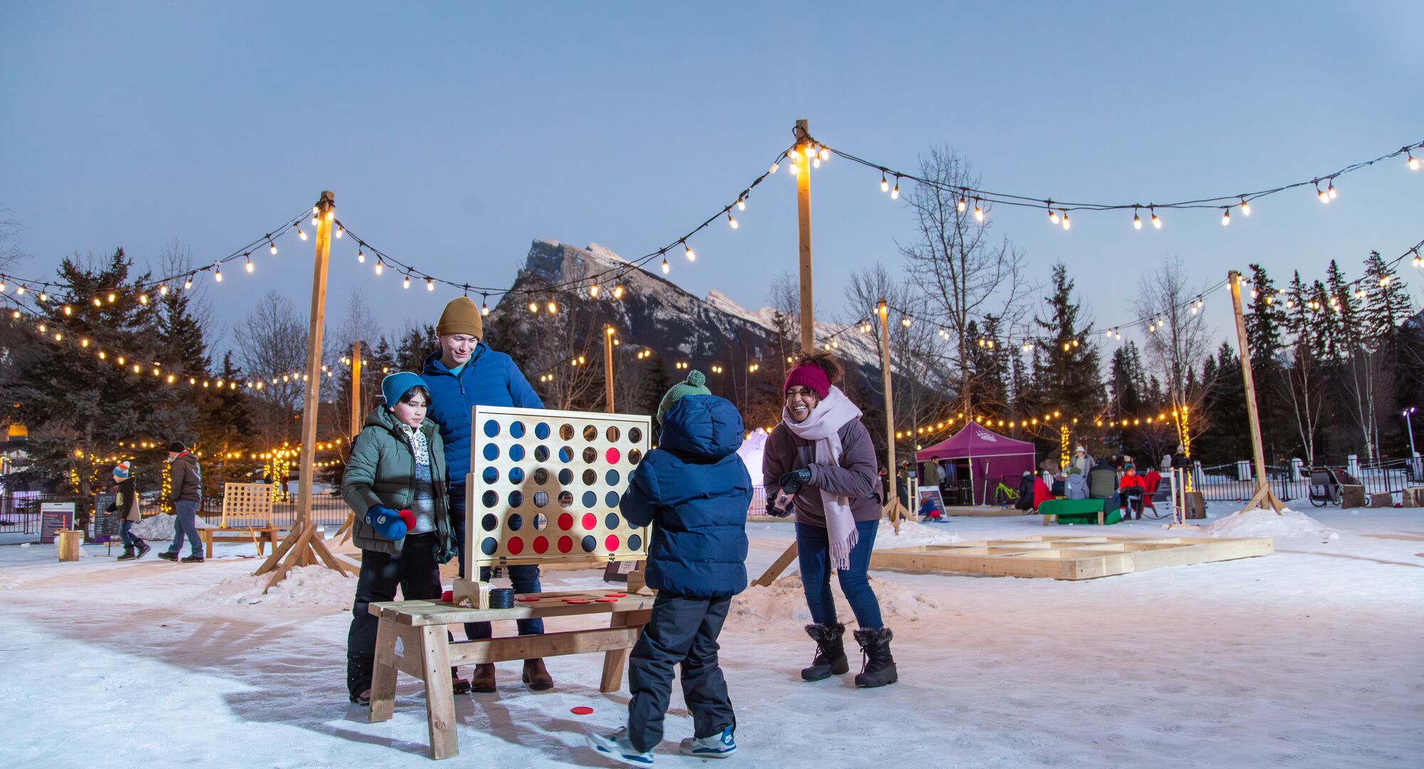 A family of four playing at the play zone during the SnowDays Festival in Banff National Park