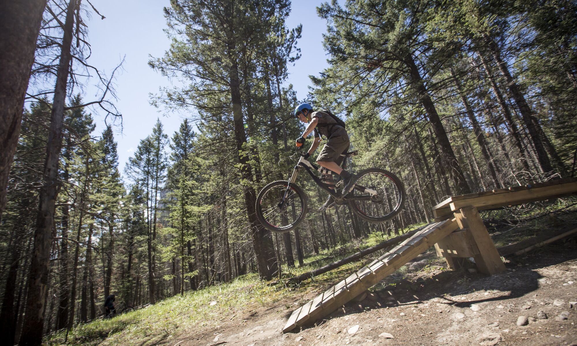 A mountain biker hits a jump on the Tunnel Mountain Trails in Banff National Park.