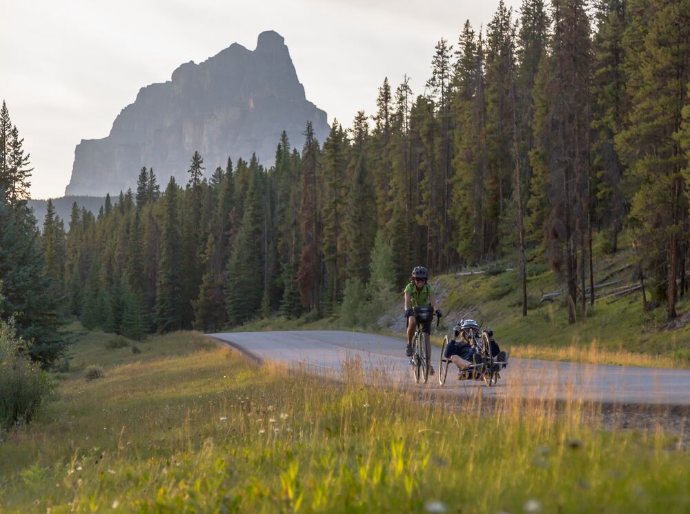 Two cyclists on a summer day ride the Bow Valley Parkway in Banff National Park.