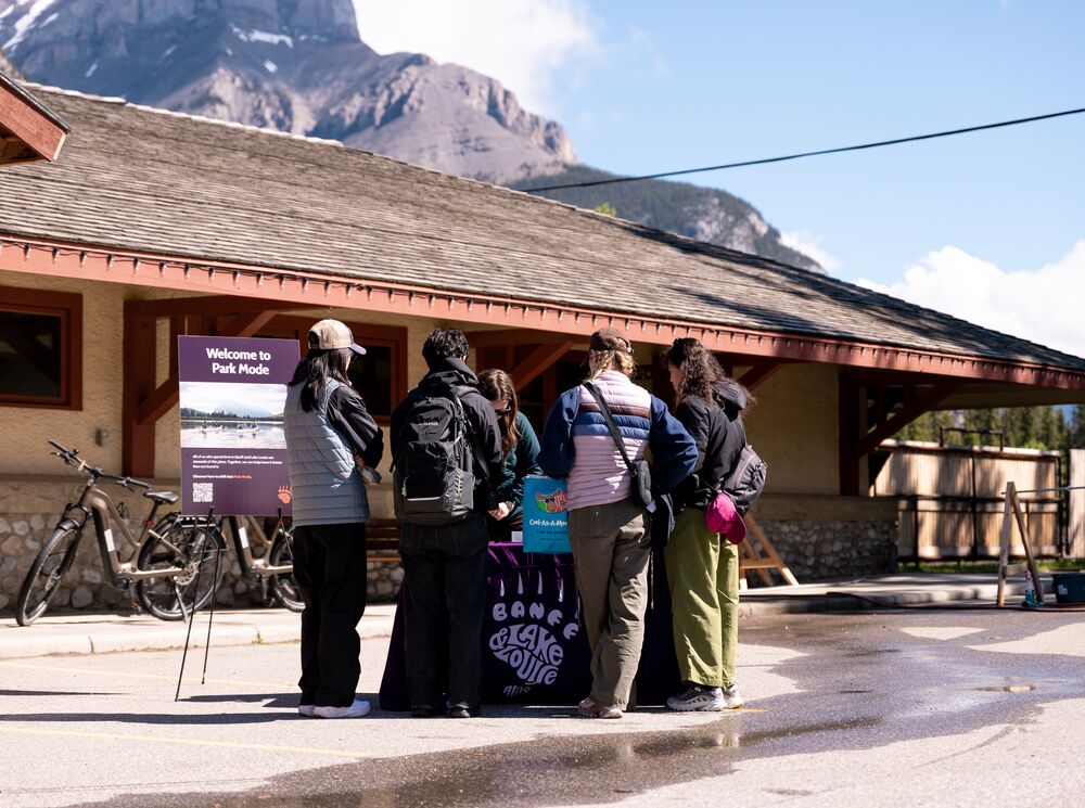 Visitors learn about Park Mode and responsible travel at an activation event outside the Banff Train Station in Banff National Park.