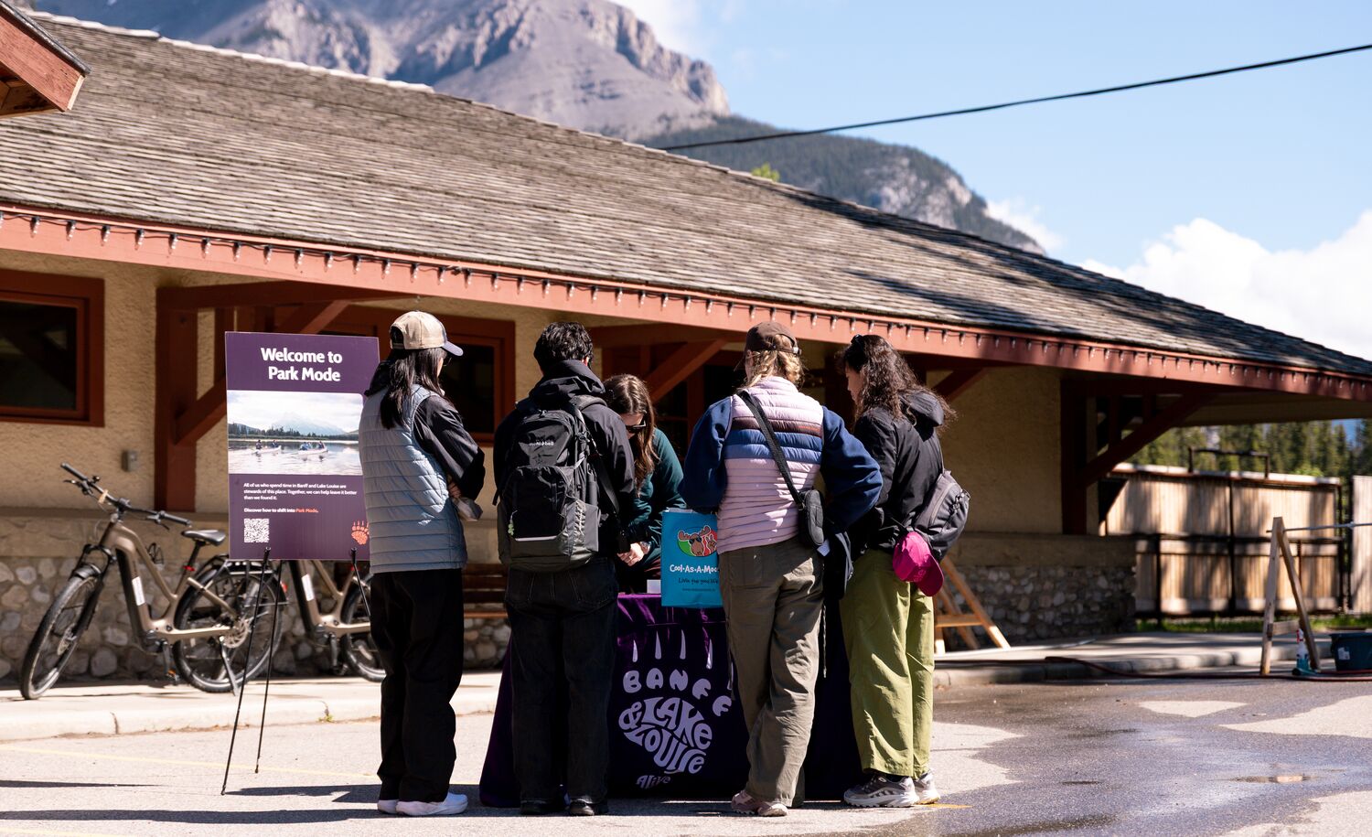 Visitors learn about Park Mode and responsible travel at an activation event outside the Banff Train Station in Banff National Park.