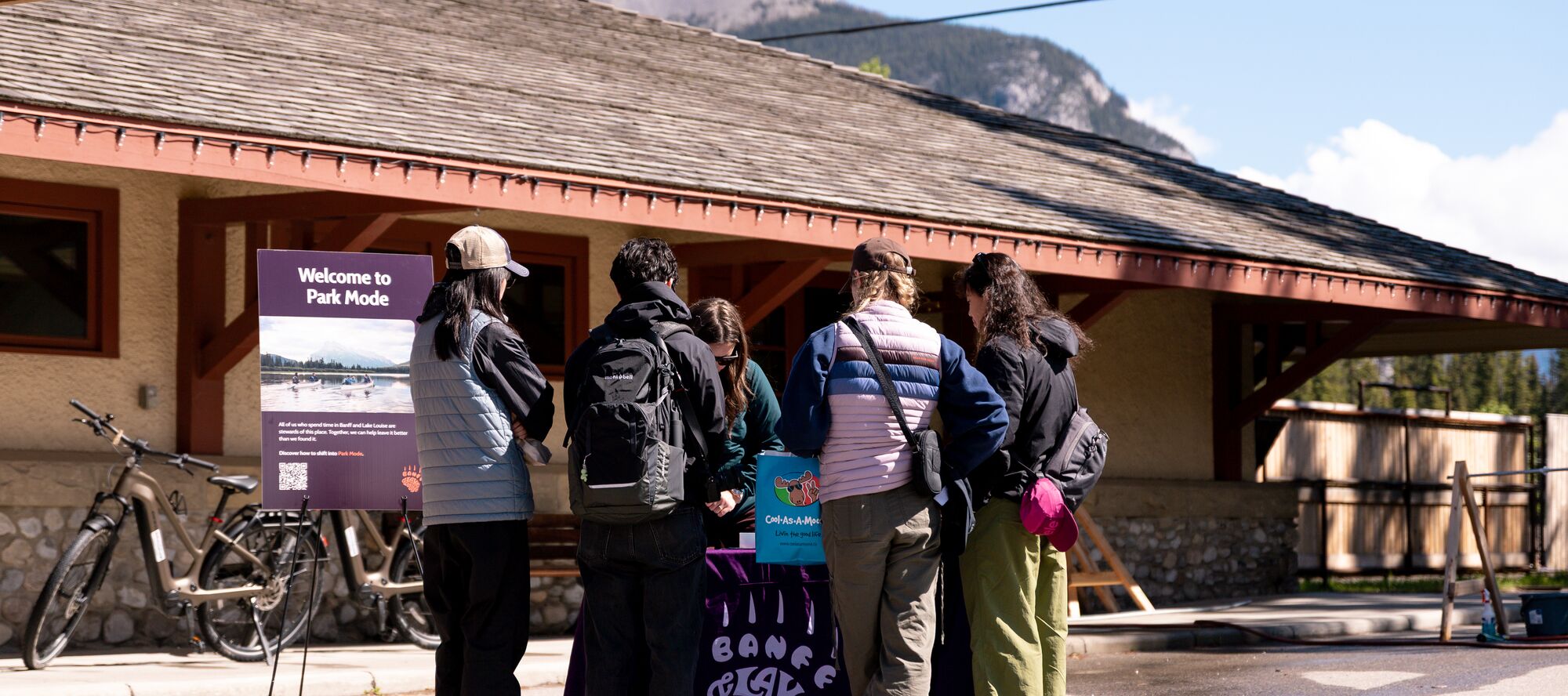 Visitors learn about Park Mode and responsible travel at an activation event outside the Banff Train Station in Banff National Park.