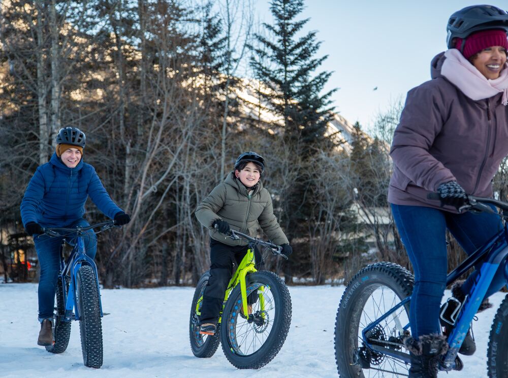A mom and two children fat biking in Banff National Park