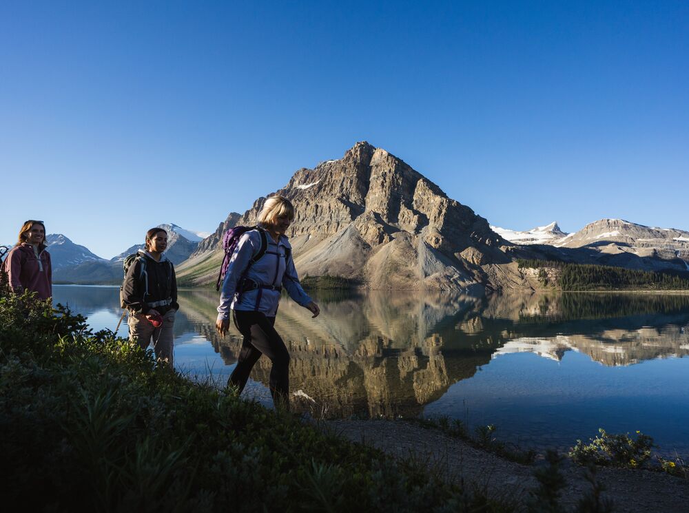 A group of people hiking along a lakeshore in Banff National Park