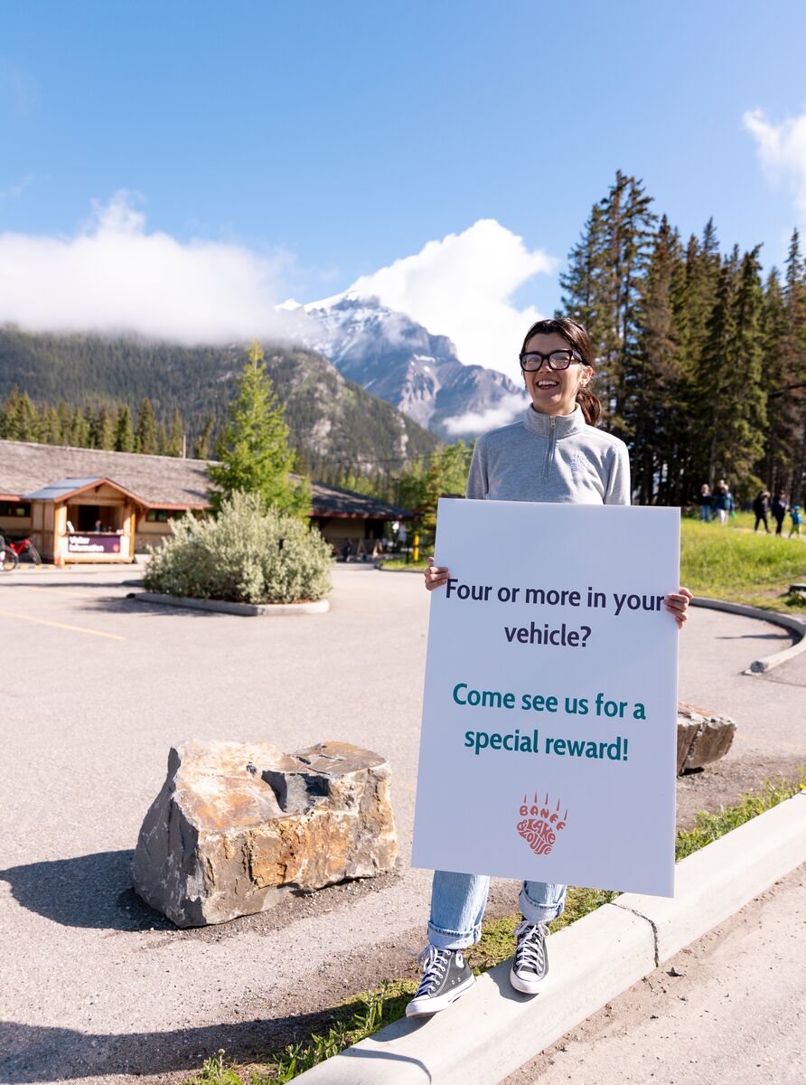 A Park Mode ambassador promotes carpooling incentives during a responsible travel pilot at the Banff Train Station in Banff National Park.