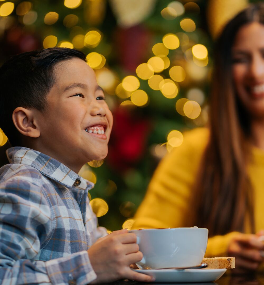 A child enjoying a big hot chocolate for the Hot Chocolate Trail in Banff and Lake Louise.