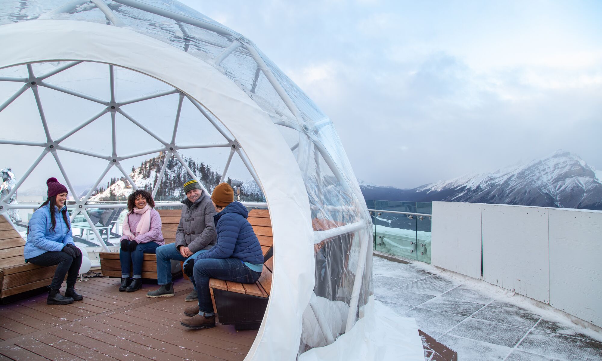 Four people on top of the Banff gondola in winter in Banff National Park