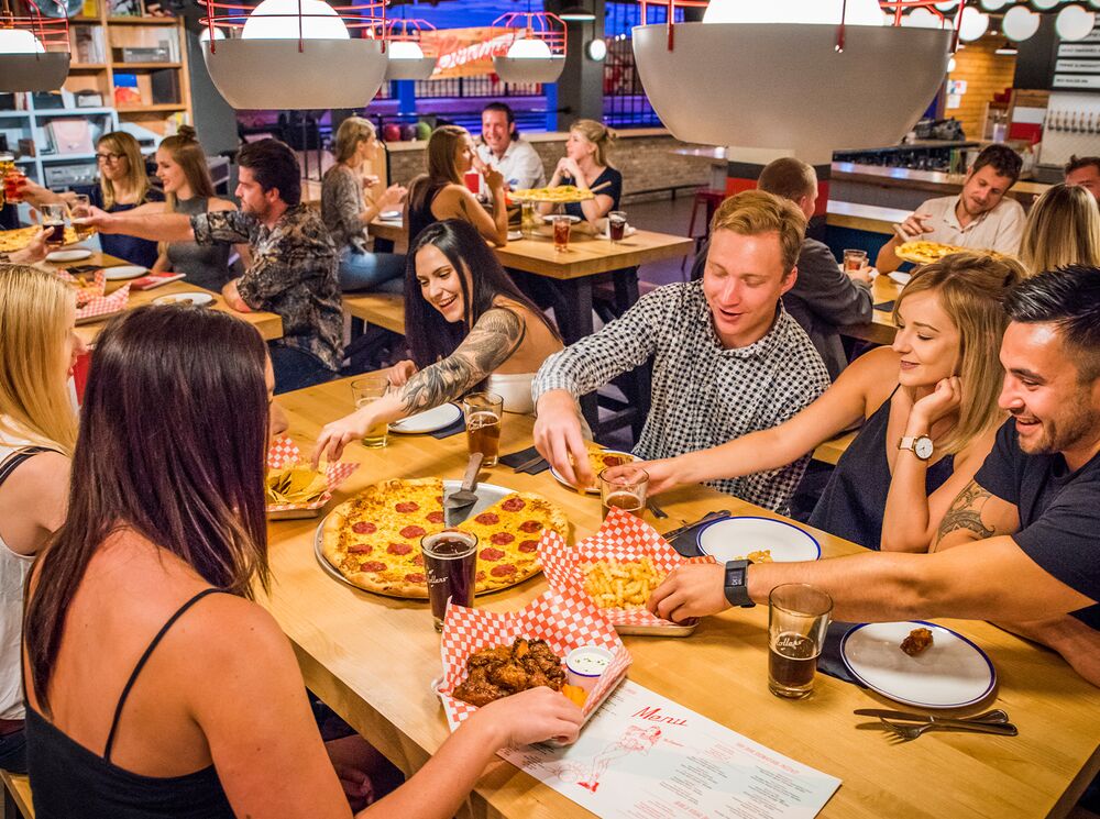 A group of friends eating pizza at a restaurant in Banff National Park