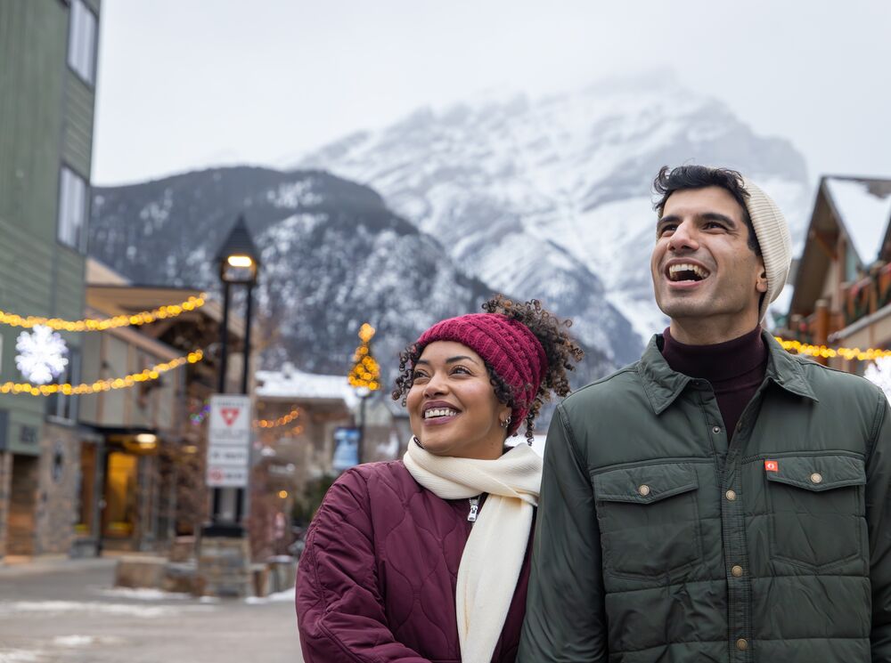 A couple walking down the street in winter in Banff National Park