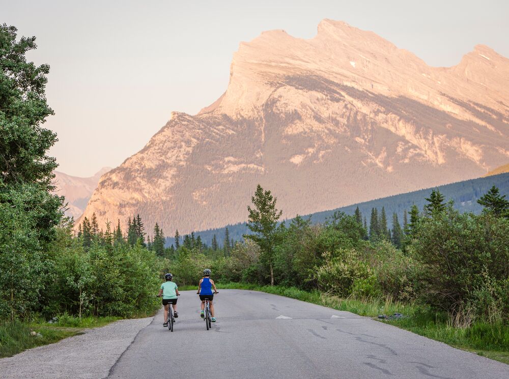 Two people biking on Vermillion Lakes road in Banff National Park