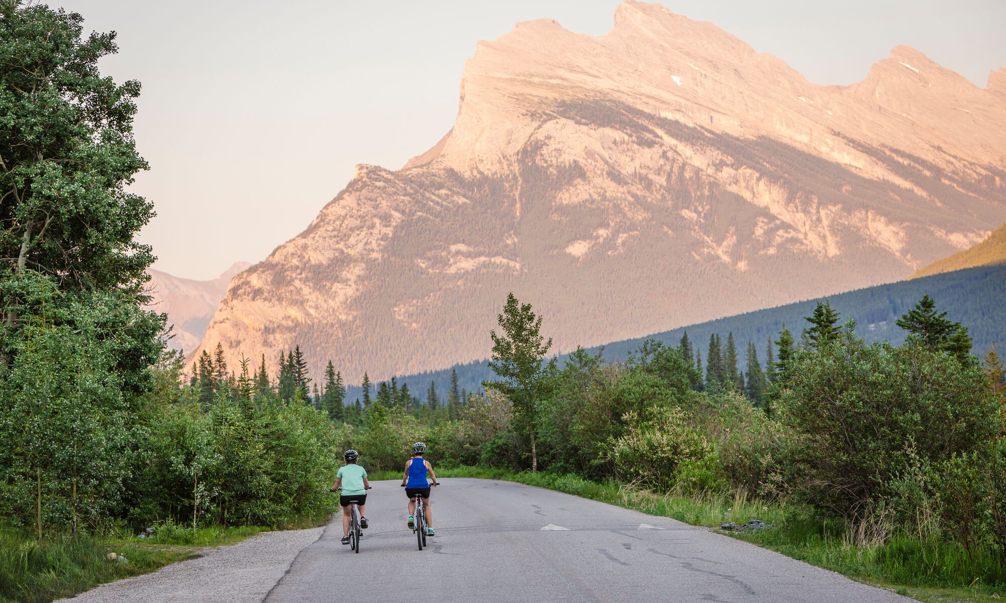 Two people biking on Vermillion Lakes road in Banff National Park