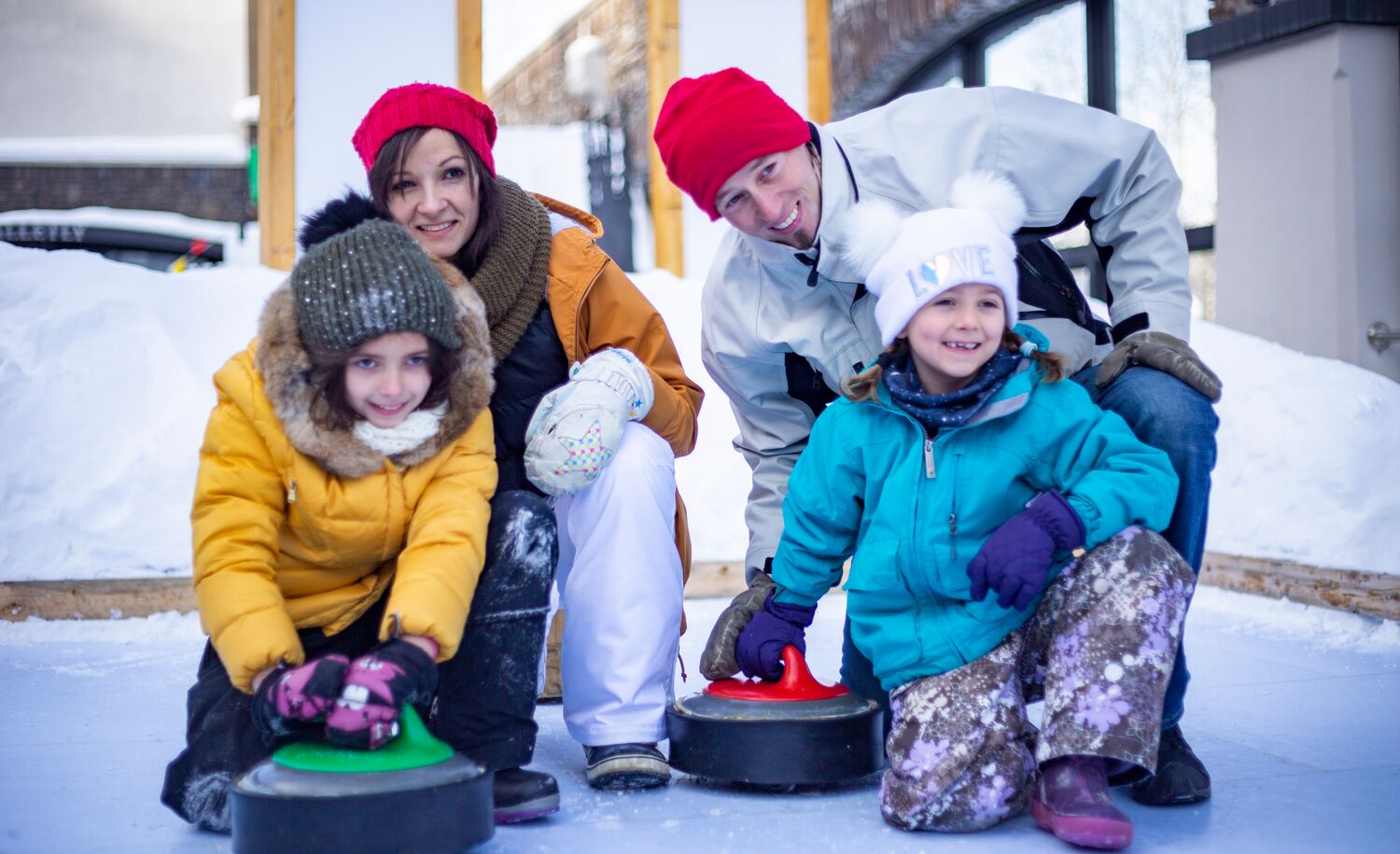 A family of four playing curing at the winter carnival in Banff National Park