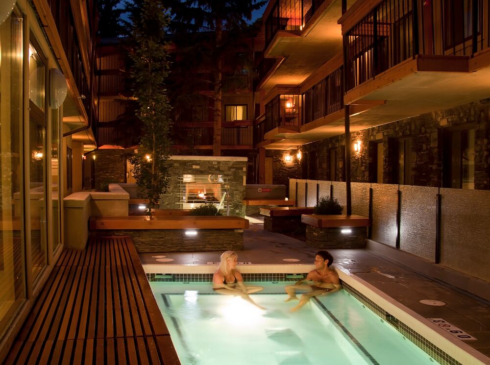 Two people sitting in an outdoor hot tub in Banff National Park