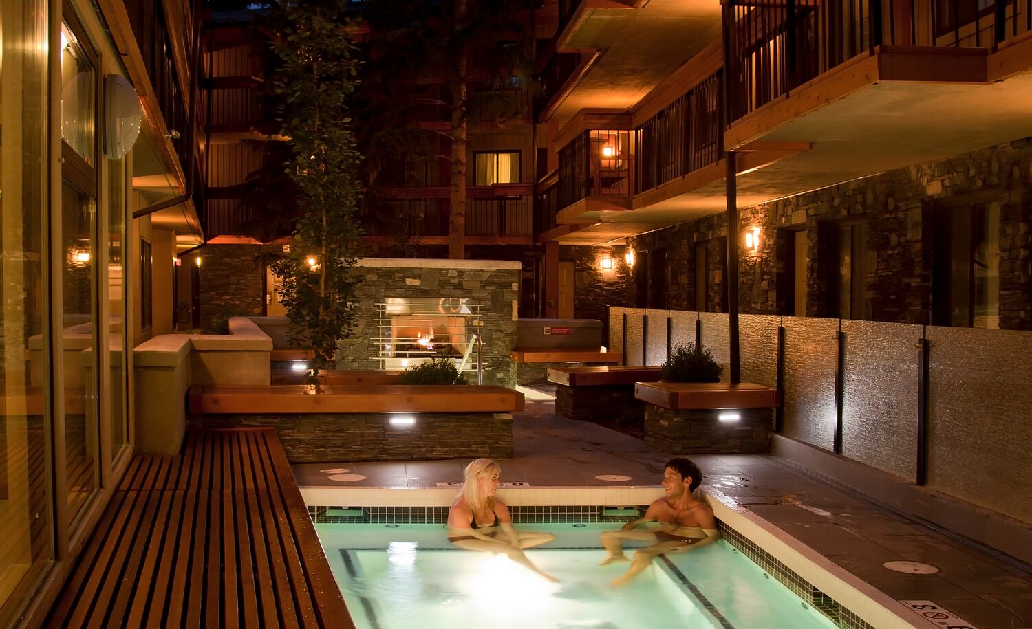 Two people sitting in an outdoor hot tub in Banff National Park