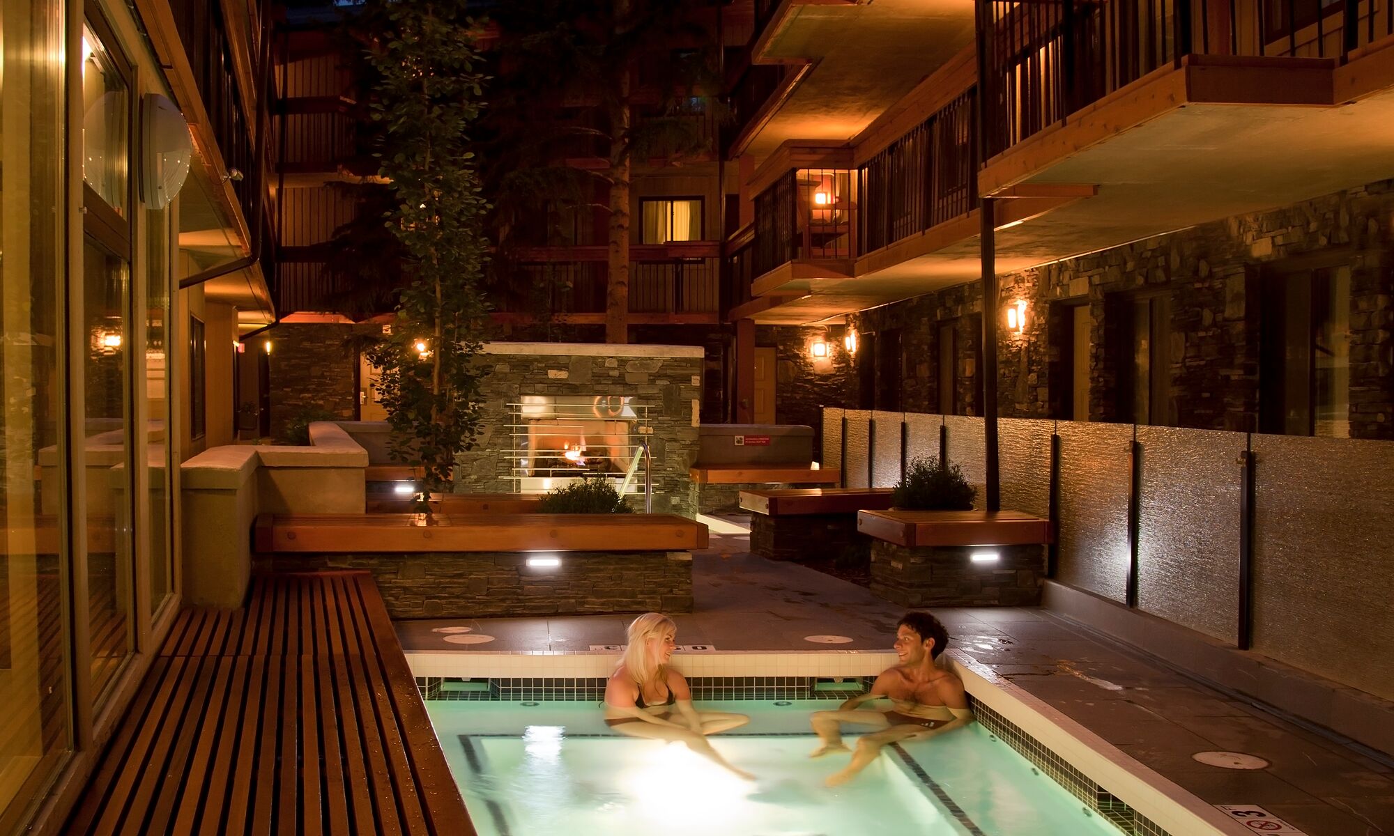 Two people sitting in an outdoor hot tub in Banff National Park