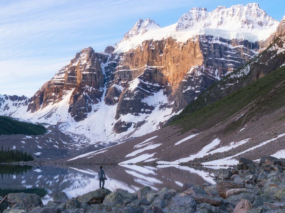 A person stands at the edge of the Moraine Lake hike Consolation Lakes in Banff National Park.