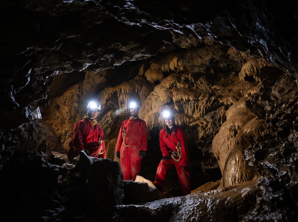 Three people caving in the Canadian Rocky Mountains