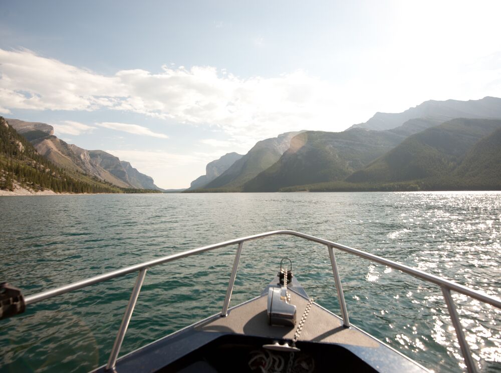 Looking off the nose of a boat in Lake Minnewanka towards the mountains.