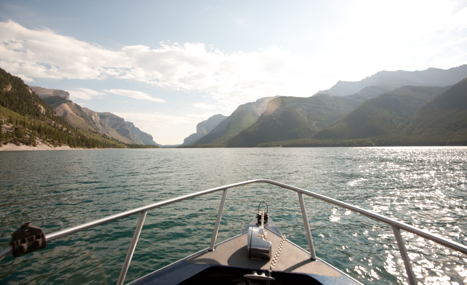 Looking off the nose of a boat in Lake Minnewanka towards the mountains.
