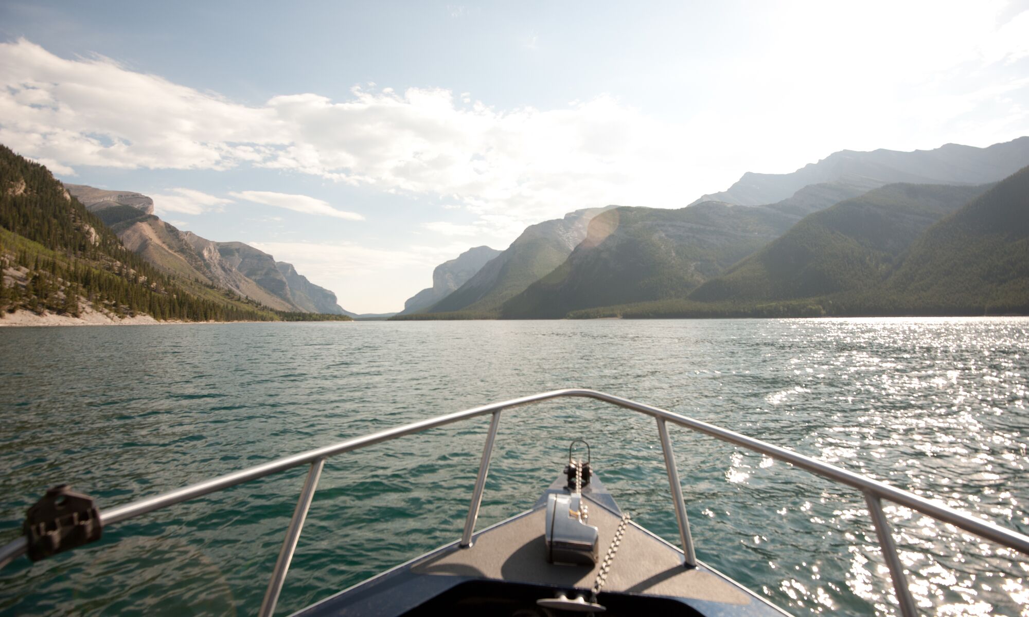 Looking off the nose of a boat in Lake Minnewanka towards the mountains.