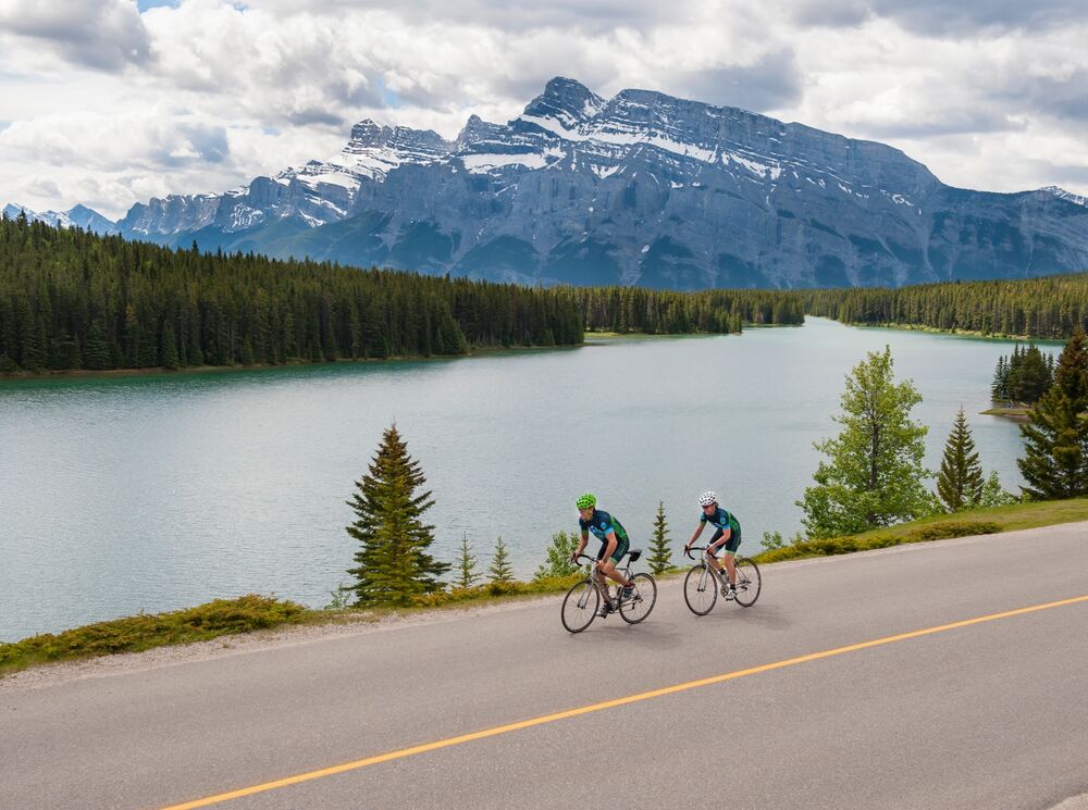 Two people biking along Two Jack Lake in Banff National Park