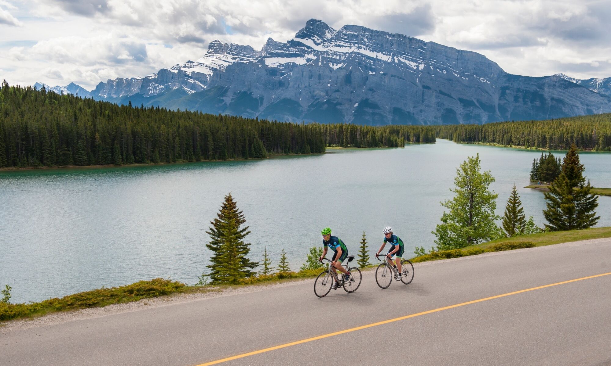 Two people biking along Two Jack Lake in Banff National Park