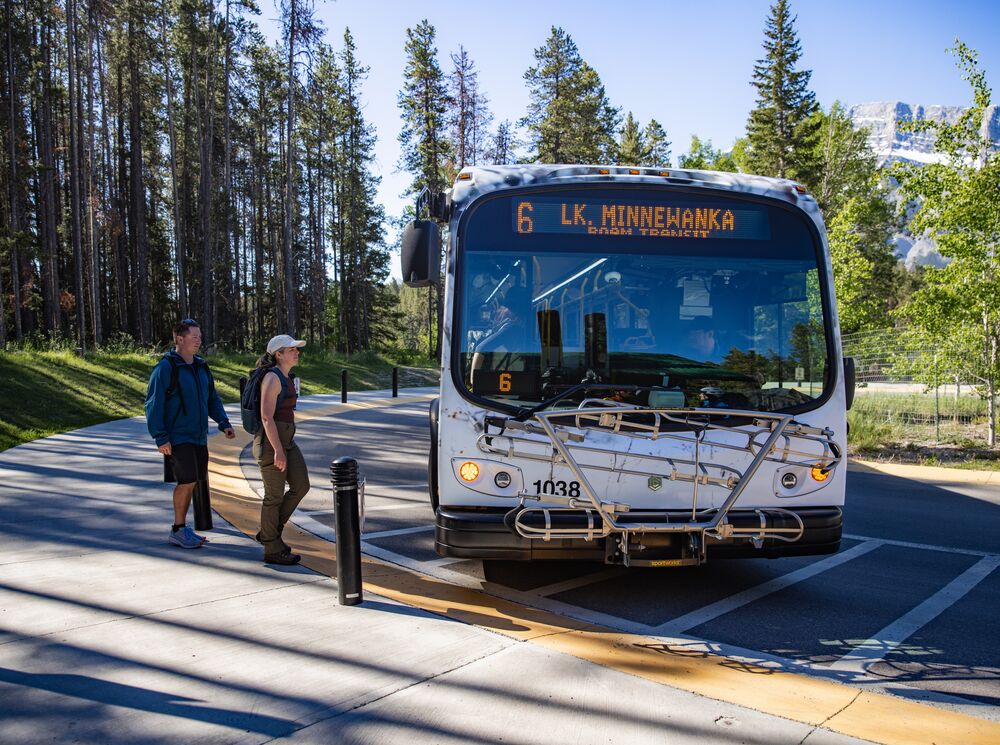 Two people getting on a Roam Transit bus in Banff National Park