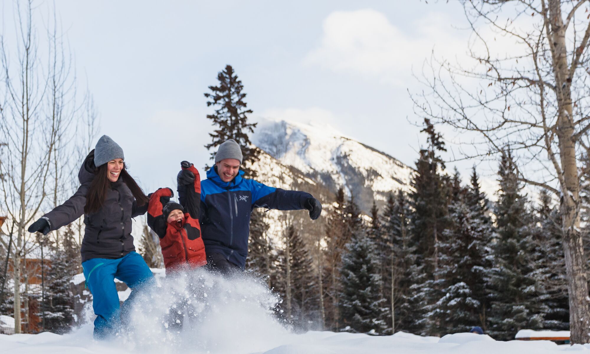 A family of three playing in the snow in Banff National Park