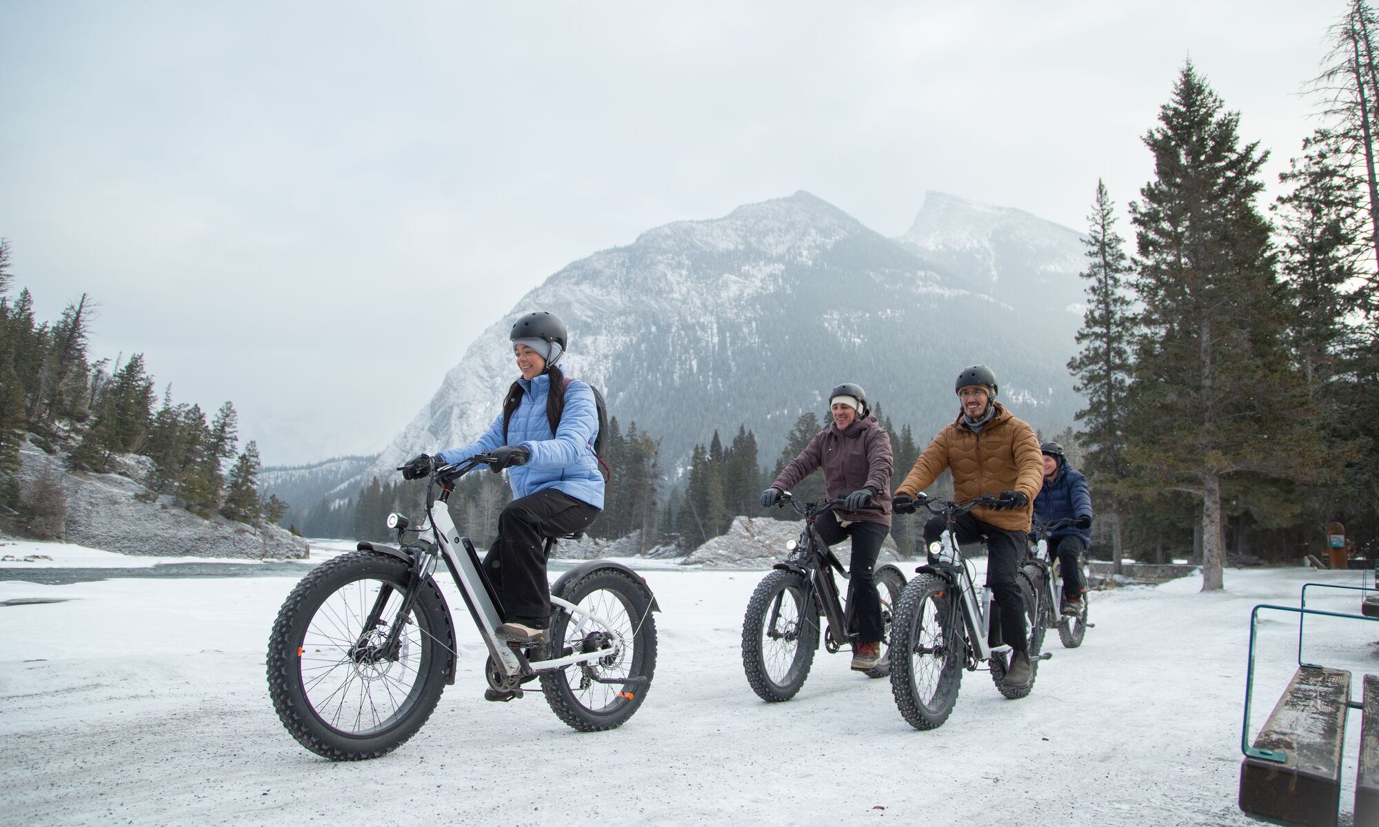 A group of friends fat biking along the Bow River in Banff National Park