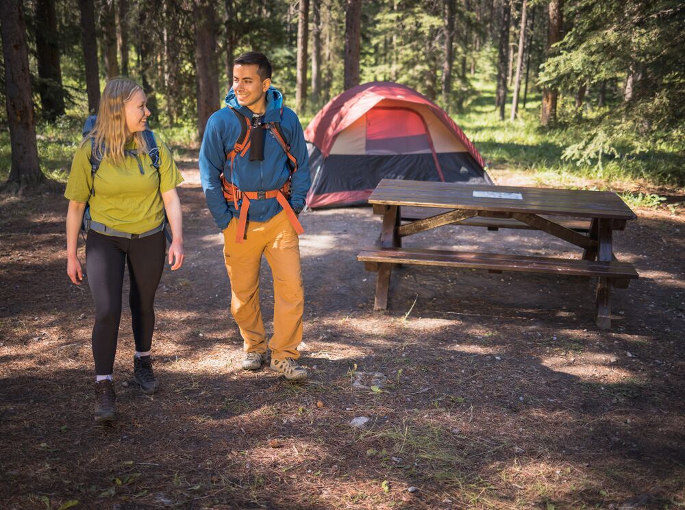 Two people walking away from their campsite in Banff National Park